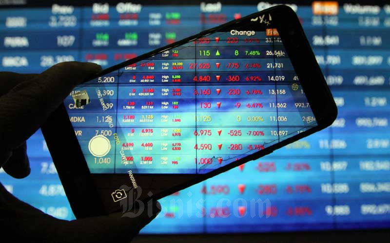 Pengunjung menggunakan smarphone memotret papan elektronik yang menampilkan perdagangan harga saham di Bursa Efek Indonesia di Jakarta, Seni (16/3/2020). Bisnis/Dedi Gunawan