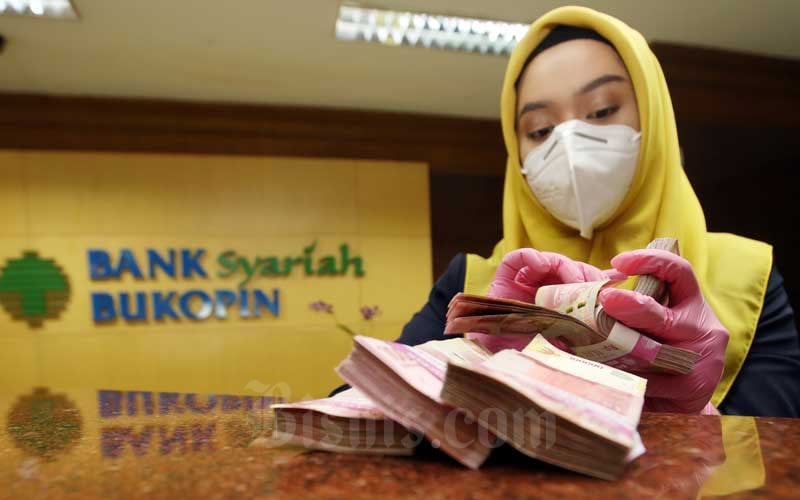 Karyawan menghitung mata uang rupiah di Bank Bukopin Syariah, Jakarta, Kamis (11/2/2021). Bisnis/Abdullah Azzam