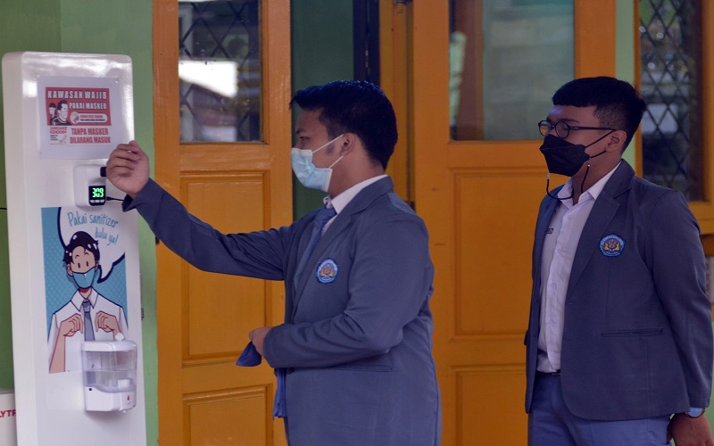 rnPelajar mengecek suhu badannya sebelum memasuki ruang kelas di SMA Negeri 2 Bandar Lampung, Lampung, Senin (13/9/2021). Pemerintah Provinsi Lampung memulai pembelajaran tatap muka (PTM) tingkat Sekolah Menengah Atas (SMA) secara selektif dan terbatas dengan menerapkan protokol kesehatan secara ketat untuk mencegah penularan Covid-19 di lingkungan sekolah./ANTARA FOTO/ Ardiansyah