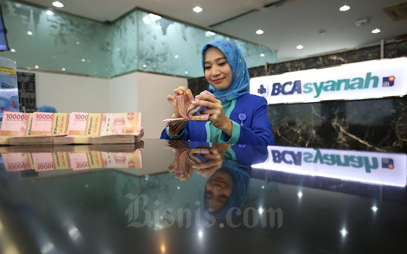Karyawan menghitung uang rupiah di kantor cabang Bank BCA Syariah di Jakarta, Selasa (7/1/2020). Bisnis/Abdullah Azzam