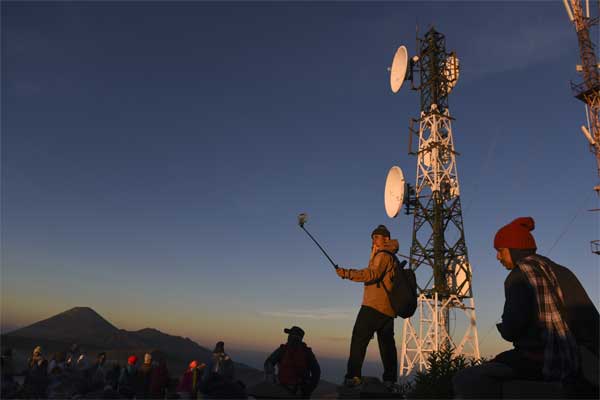 Wisatawan menikmati pemandangan Gunung Bromo dengan latar belakang Base Transceiver Station (BTS) Telkomsel di penanjakan satu Probolinggo, Jawa Timur, Jumat (19/5)./Antara-Zabur Karuru