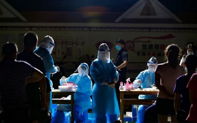 Tenaga medis dengan alat pelindung diri menghadapi warga yang mengantre untuk uji asam nukleat di sebuah halaman perumahan, menyusul kasus impor Covid-19 dari negara tetangga Myanmar, di kota perbatasan Ruili, prefektur Dehong, provinsi Yunnan, China, Rabu (16/9/2020)./Antara-Reutersrn
