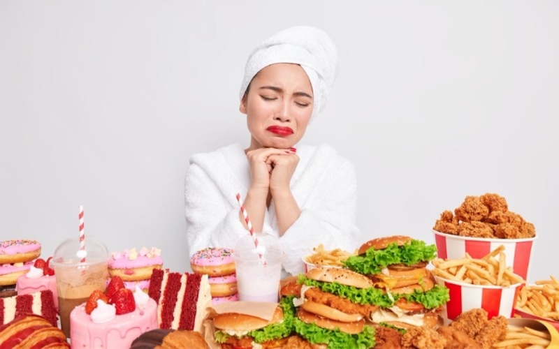 Ilustrasi wanita merasa bersalah akibat makan fast food yang mengandung kolesterol tinggi/Freepik.com