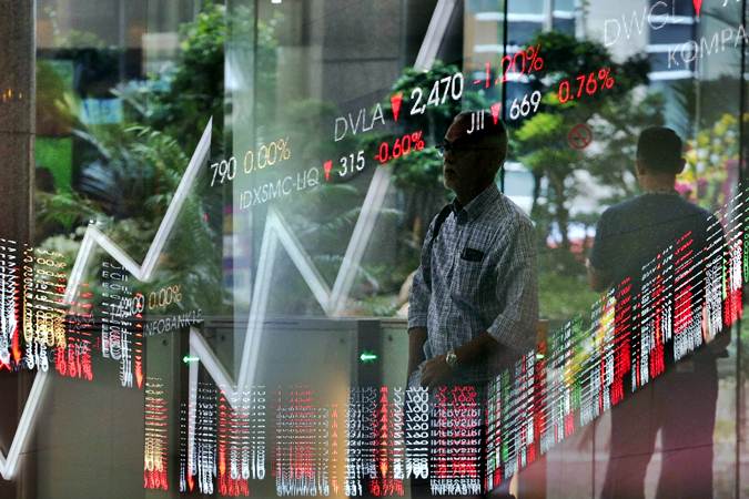 Karyawan melintas di dekat layar penunjuk pergerakan Indeks Harga Saham Gabungan (IHSG) di gedung Bursa Efek Indonesia di Jakarta, Rabu (12/6/2019)./Bisnis-Felix Jody Kinarwan