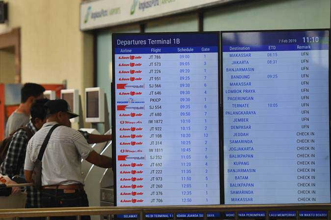 Calon penumpang mencetak tiket di samping layar informasi penerbangan di terminal keberangkatan domestik 1B Bandara Internasional Juanda Surabaya, Sidoarjo, Jawa Timur, Kamis (7/2/2019). Bandara tersebut ditutup sementara akibat rusaknya landasan pacu./ANTARA-Zabur Karuru
