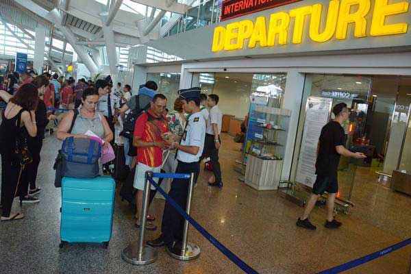 Petugas memeriksa tiket penumpang di Bandara Internasional Ngurah Rai, Bali, Rabu (29/11)./ANTARA-Wira Suryantala