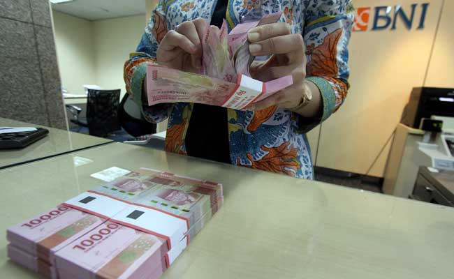 Petugas teller PT Bank Negara Indonesia (Persero) Tbk. (BNI) menghitung uang di salah satu kantor cabang BNI di Jakarta. Bisnis/Arief Hermawan P
