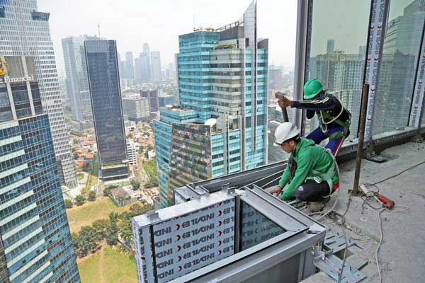 Pekerja PT Nusa Konstruksi Enjiniring Tbk (NKE) menyelesaikan pembangunan gedung World Capital Tower (WCT) setinggi 54 lantai milik Pollux Properties Group, di Mega Kuningan, Jakarta, Rabu (13/9)./ANTARA 