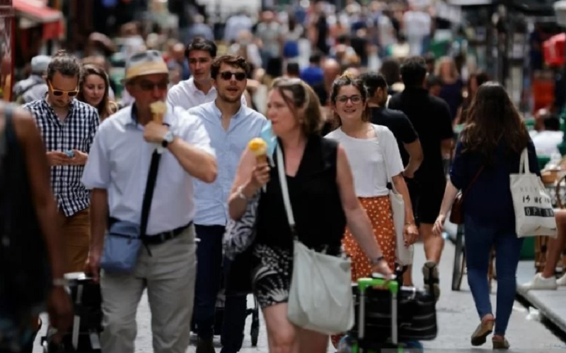 Masyarakat berjalan di sebuah jalan di Paris tanpa masker saat masker tidak diwajibkan lagi dipakai saat keluar rumah, di tengah pandemi penyakit Covid-19 di Prancis, Kamis (17/6/2021)./Antara