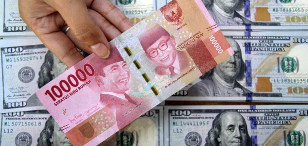 Petugas menunjukkan uang rupiah dan dolar AS di salah satu gerai penukaran mata uang asing di Jakarta, Senin (16/3/2020)./Bisnis-Arief Hermawan P 