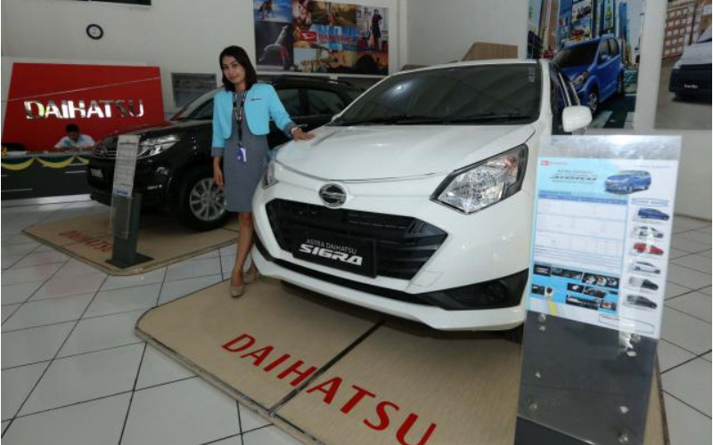 Sales Counter, Setiowati, berfoto dengan produk mobil Astra Daihatsu Sigra di dealer Astra Daihatsu Tambak Segaran, Solo, Selasa (8/11/2019). /BISNIS.COM-Ivanovich Aldino