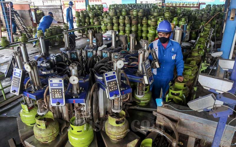 Petugas melakukan tahap pengisian LPG pada tabung gas 3kg di SPBE Srengseng, Jakarta, Senin (1/2/2021). Bisnis/Eusebio Chrysnamurti