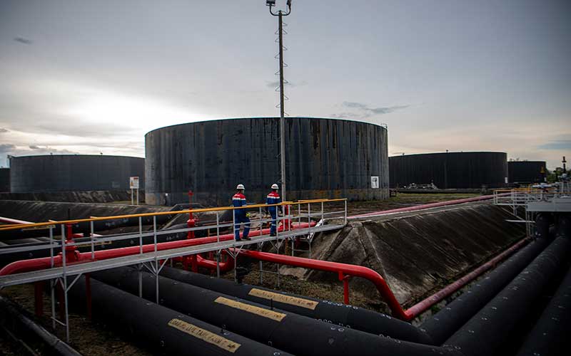 Pekerja PT Pertamina Hulu Rokan mengecek saluran pipa minyak yang menuju tangki pengumpul produksi minyak (Tank Farm) di Blok Rokan, Dumai, Riau, Rabu (22/12/2021). ANTARA FOTO/Nova Wahyudi