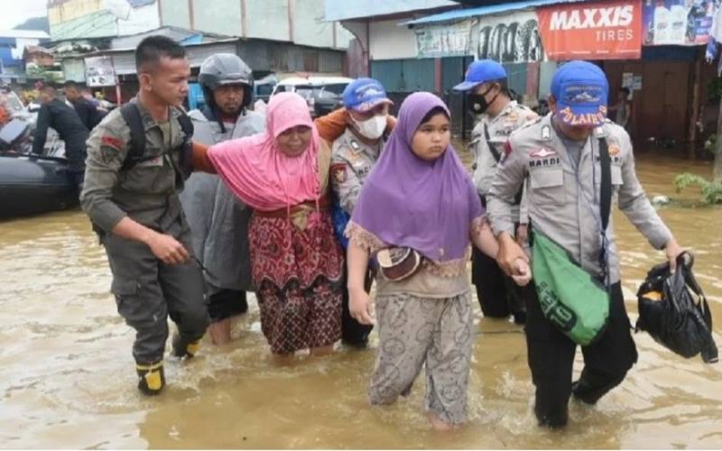 Anggota Polda Papua membantu warga terdampak banjir di kawasan Pasar Youtefa, Jumat (7/1/2022)./Antara