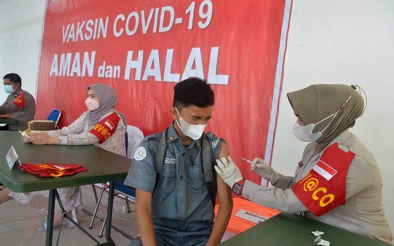 Petugas kesehatan menyuntikkan vaksin COVID-19 kepada seorang pelajar di gedung Taman Budaya, Banda Aceh, Aceh, Senin (6/12/2021). Pemerintah akan melakukan vaksinasi COVID-19 dosis ketiga atau booster/penguat secara paralel pada Januari 2022 kepada masyarakat secara gratis dan sebagian lainnya berbayar. ANTARA FOTO/Ampelsa/wsj.