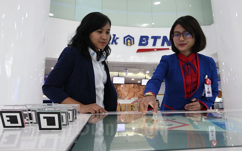 Karyawati PT Bank Tabungan Negara memberikan penjelasan mengenai produk perbankan kepada nasabah di Jakarta, Senin (8/1). Bisnis/Dedi Gunawan