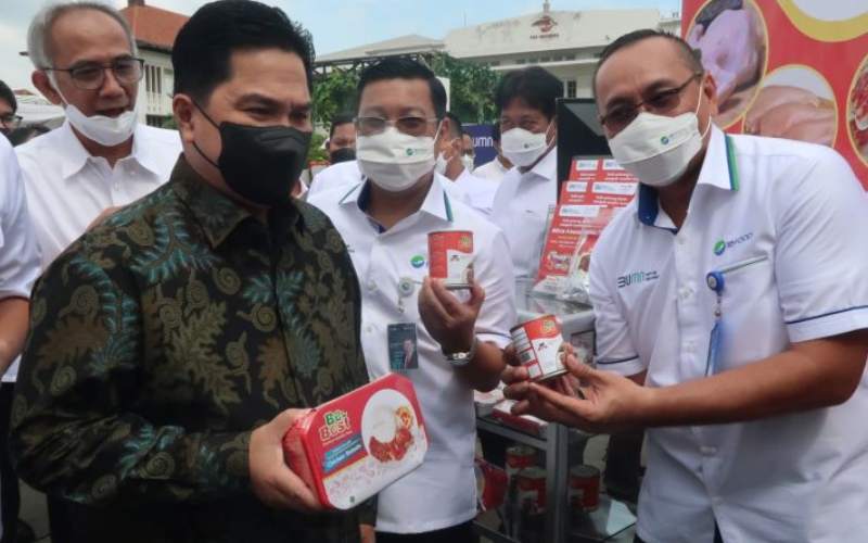 Menteri BUMN Erick Thohir (kiri) memperlihatkan produk olahan daging ayam kepada wartawan yang hadir dalam peluncuran holding BUMN Pangan di kawasan Kota Tua, Jakarta, Rabu (12/1/2022). (ANTARA/Sugiharto Purnama)