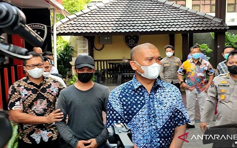 Polisi saat membawa pelaku penendang sesajen untuk menjalani pemeriksaan di Mapolda Jatim, Surabaya, Jumat (14/1/2022)./Antara-Willy Irawan.