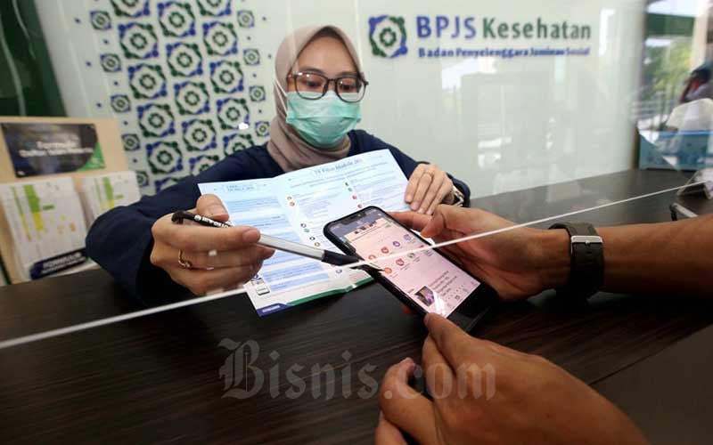 Petugas menjelaskan kepada peserta tentang fitur-fitur yang ada di aplikasi Mobile JKN di Kantor BPJS Kesehatan Cabang Bandung, Jawa Barat, Kamis (13/8/2020). Bisnis/Rachman