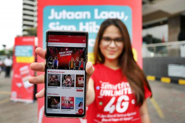 Model memperlihatkan aplikasi khusus streaming musik dari Smartfren yaitu SmartMusic saat peluncurannya di Jakarta, Minggu (10/2/2019)./Bisnis-Abdullah Azzam