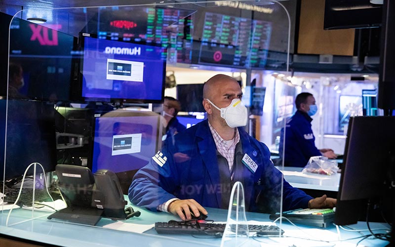 Pekerja berada di lantai Bursa Efek New York (NYSE) di New York, AS, Senin (3/1/2021). Bloomberg/Michael Nagle
