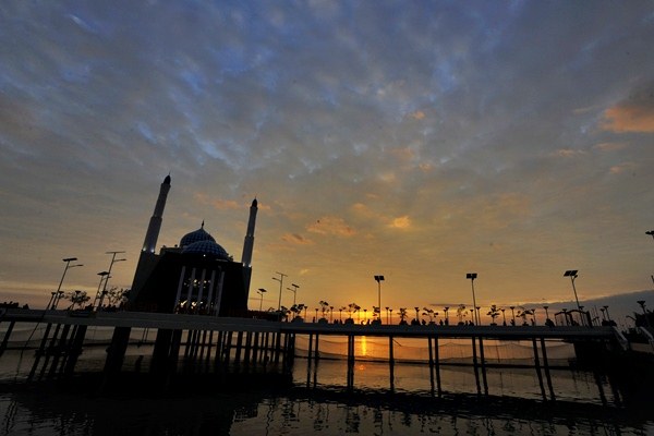 Umat muslim menikmati terbenamnya matahari (sunset) di pelataran Masjid Terapung Amirul Mukminin, Pantai Losari, Makassar, Sulawesi Selatan, Senin (22/6/2015)./Antara-Yusran Uccang