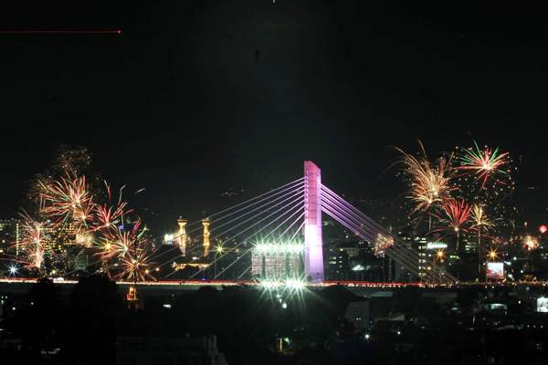 Pesta kembang api menghiasi langit di kawasan Jembatan layang Pasteur-Surapati (Pasupati) pada malam detik detik pergantian tahun di Bandung, Jawa Barat./Bisnis
