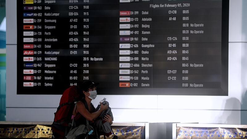 Penumpang melintas di dekat layar informasi penerbangan di Terminal Keberangkatan Internasional Bandara Internasional I Gusti Ngurah Rai, Bali, Selasa (4/2/2020)./ ANTARA - Fikri Yusuf