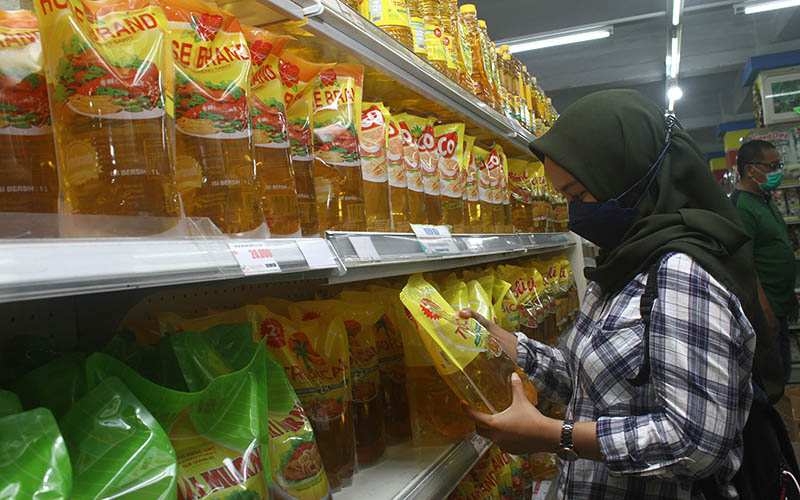 Seorang pengunjung memilih minyak goreng yang dijual di supermarket di Pontianak, Kalimantan Barat, Kamis (23/12/2021). /Antara Foto-Jessica Helena Wuysang-hp.rn