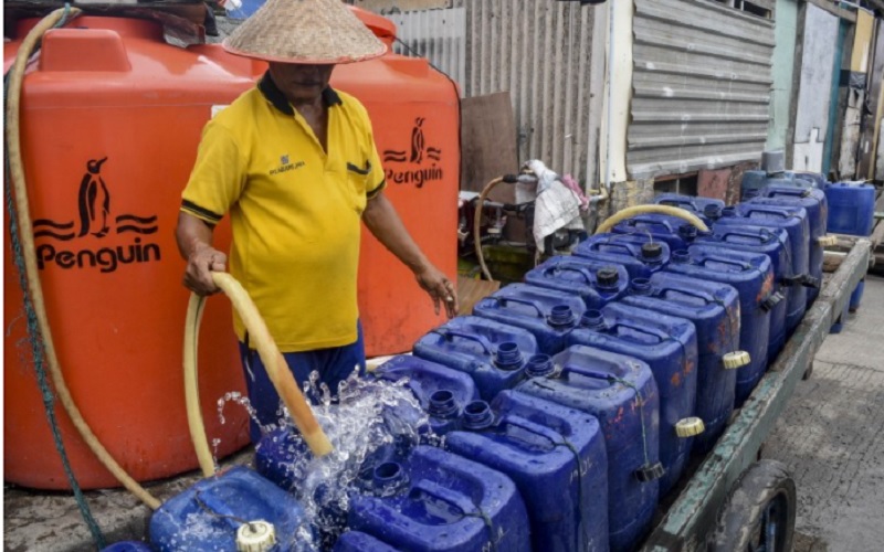 Pekerja mengisi air bersih ke dalam jerigen untuk dijual di Muara Angke, Jakarta./Antara