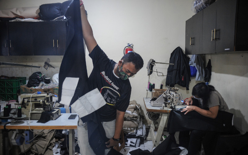 Pekerja menyelesaikan produksi celana di salah satu industri tekstil, Kopo, Kabupaten Bandung, Jawa Barat, Jumat (21/1/2021). -ANTARA