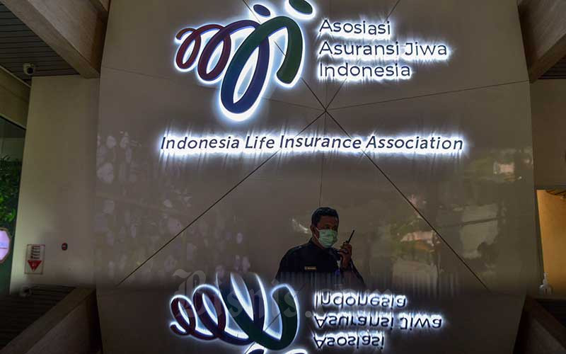 Karyawan beraktivitas di dekat logo-logo asuransi jiwa di kantor Asosiasi Asuransi Jiwa Indonesia (AAJI), Jakarta, Kamis (23/12/2021). Bisnis/Fanny Kusumawardhani