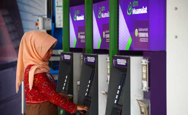 Nasabah menggunakan mesin anjungan tunai mandiri bank Muamalat di Jakarta. Bisnis