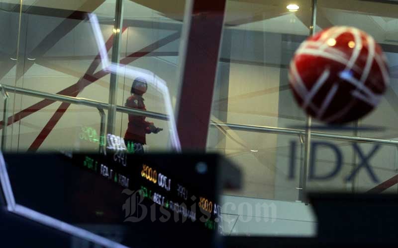 Karyawan melintas di dekat layar elektronik yang menampilkan pergerakan Indeks Harga Saham Gabungan (IHSG) di PT Bursa Efek Indonesia (BEI), Jakarta, Selasa (9/6/2020). Bisnis/Arief Hermawan P