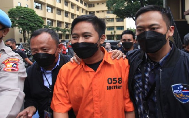 Polisi menggiring tersangka kasus penipuan aplikasi Quotex Doni Salmanan (tengah) saat konferensi pers di Bareskrim, Mabes Polri Jakarta, Selasa (15/3/2022)./Antara