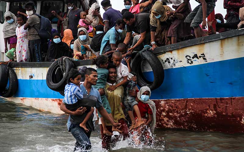 Warga mengevakuasi pengungsi etnis Rohingya dari kapal di pesisir pantai Lancok, Aceh Utara, Aceh, pada Kamis (25/6/2020)./Antara-Rahmad