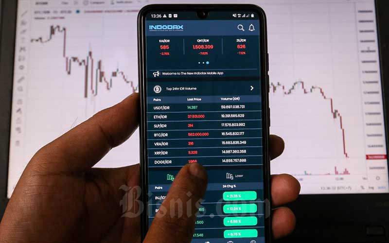 Investor memantau pergerakan harga kripto melalui ponselnya di Jakarta, Minggu (20/2/2022). Bisnis/Eusebio Chrysnamurti