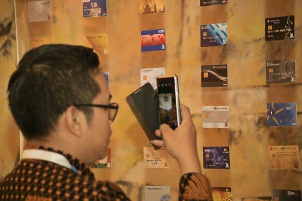 Pengunjung mengamati kartu berlogo Gerbang Pembayaran Nasional di sela-sela peluncurannya di Jakarta, Kamis (3/5/2018)./JIBI-Felix Jody Kinarwan 