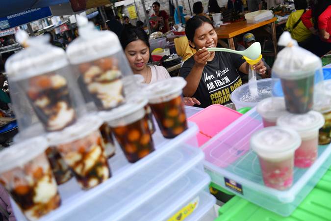 Pedagang membungkus minuman untuk dijual di Pasar Takjil Benhil, Jakarta, Senin (6/5/2019)./ANTARA-Sigid Kurniawan