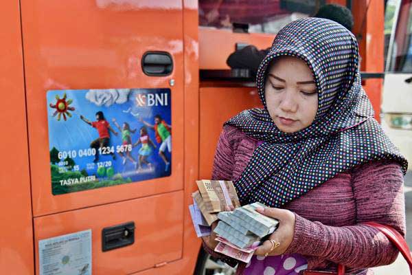 Warga membawa uang yang baru ditukarkan di loket mobil kas keliling, di Semarang, Jawa Tengah, Selasa (6/6)./Antara-R. Rekotomo