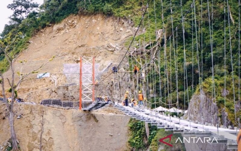 Pengerjaan jembatan gantung Gladak Perak di Kabupaten Lumajang, Jatiim, terdampak awan panas Gunung Semeru, yang ditargetkan rampung sebelum Lebaran 2022./Antara-Diskominfo Lumajang.