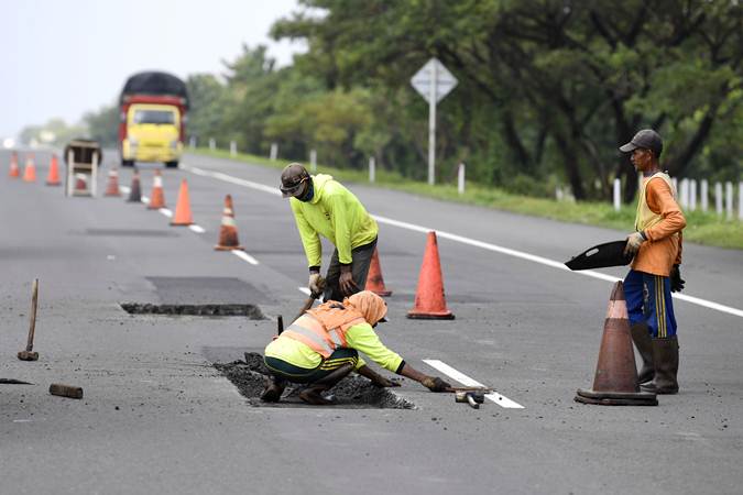 Pekerja menyelesaikan perbaikan jalan tol Brebes-Pejagan, Jawa Tengah, Minggu (12/5/2019)./ANTARA-Puspa Perwitasari