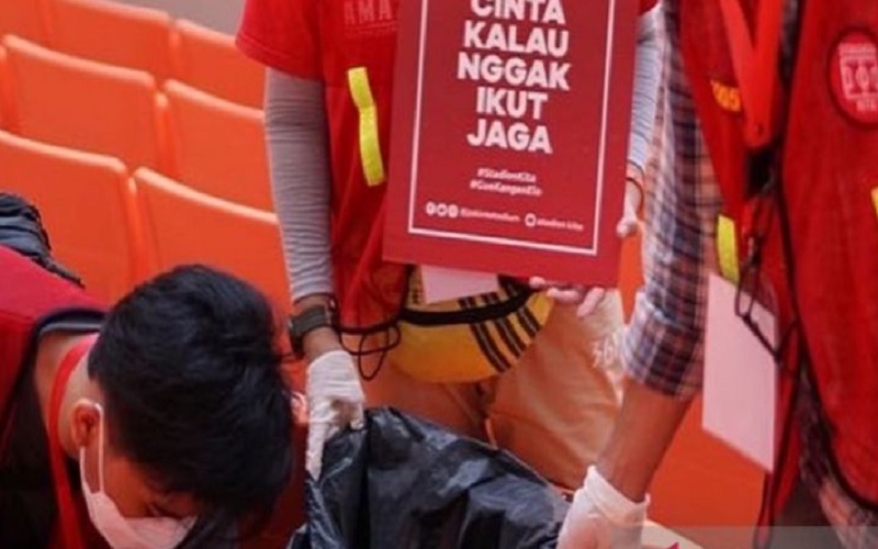 Salah satu petugas memungut sampah atau Operasi Semut saat turnamen International Youth Championship (IYC) 2021 di Jakarta International Stadium (JIS) Jakarta Utara, Minggu (17/4/2022) malam./Antara