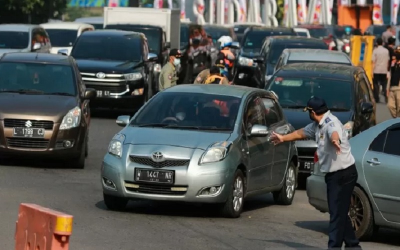 Petugas mengatur lalu lintas kendaraan yang akan masuk ke Kota Surabaya saat hari pertama larangan mudik di kota setempat, Kamis (6/5/2021)./Antara rn