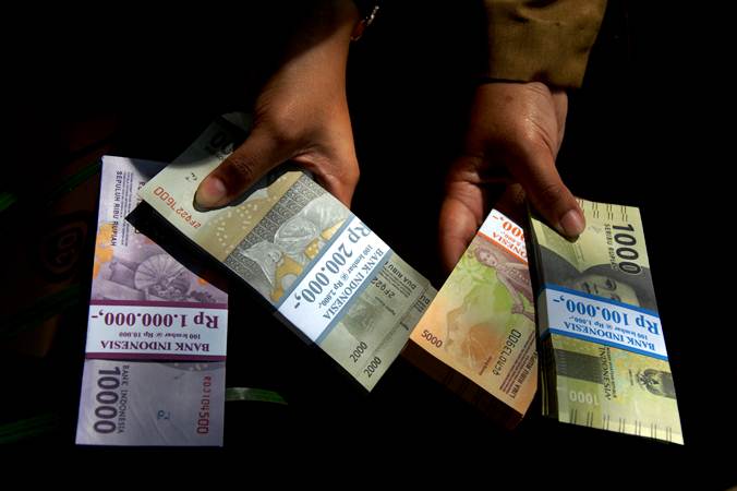 Warga menunjukkan uang rupiah pecahan kecil di Lapangan Karebosi, Makassar, Sulawesi Selatan, Senin (13/5/2019). /Antara-Abriawan Abhe