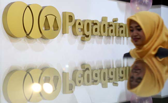 Karyawan melintas didekat logo  PT Pengadaian (Persero) di Jakarta, Senin (17/2/2020). Bisnis/Abdullah Azzam