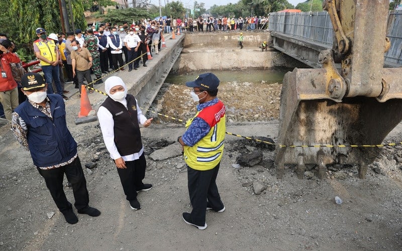 Gubernur Jawa Timur Khofifah Indar Parawansa (tengah) bersama Bupati Lamongan Yuhronur Efendi (kiri) dan Kepala BBPJN Jatim - Bali Achmad Subki (kanan) meninjau perbaikan Jembatan Ngaglik yang ambles di Lamongan, Jawa Timur, Jumat (1/4/2022). Perbaikan jembatan yang berada di jalan poros nasional tersebut ditargetkan selesai pada 22 April atau H-10 Lebaran./Antara-Trisnadi.
