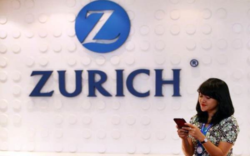 Karyawati mengoperasikan ponsel pintar di dekat logo Zurich Insurance Indonesia di Jakarta, Senin (29/5)./JIBI-Dwi Prasetya