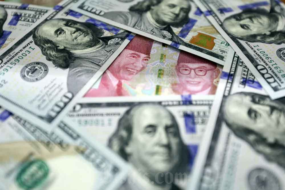 Uang dolar dan rupiah di Dolarindo Money Changer, Jakarta, Selasa (26/4/2022) Bisnis/Himawan L Nugraha