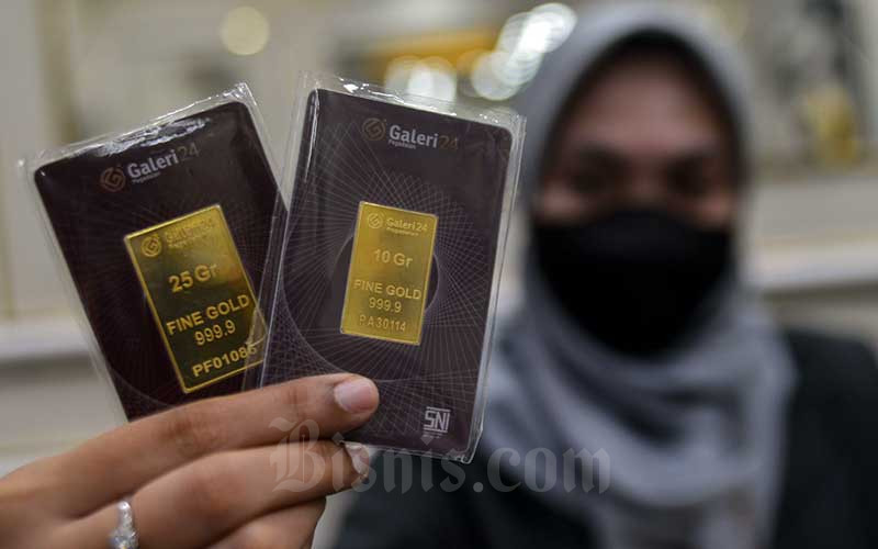 Karyawan menunjukan emas batangan di Galeri 24 Pegadaian, Jakarta, Senin (14/2/2022). Bisnis/Fanny Kusumawardhani